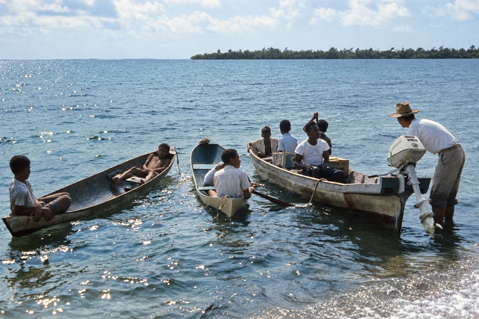 People in small wooden boats on coastal water